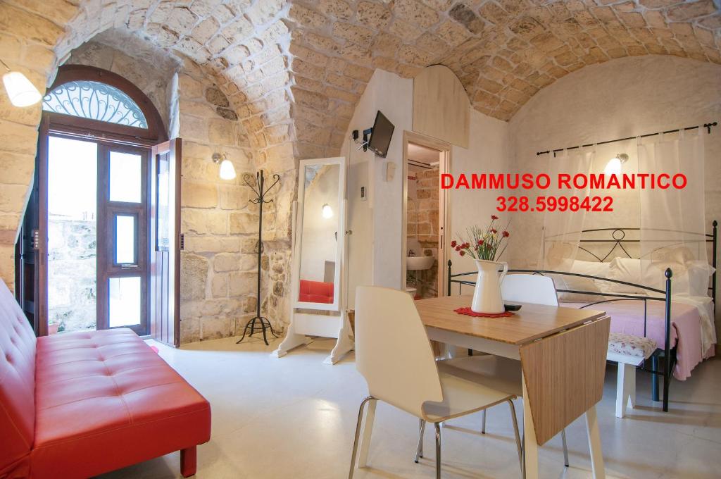 ein Wohnzimmer mit einem Tisch und ein Schlafzimmer in der Unterkunft Dammuso Romantico in Scicli
