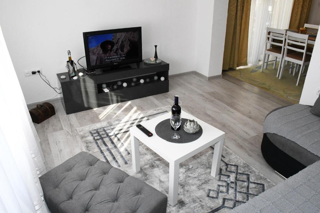 a living room with a white table and a tv at Apartment Sarajlic in Prijedor