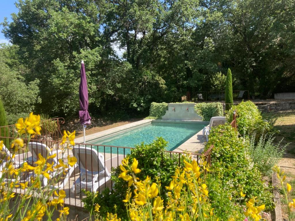 una piscina in un giardino con sedie e fiori di La Bastide des Milles ad Apt