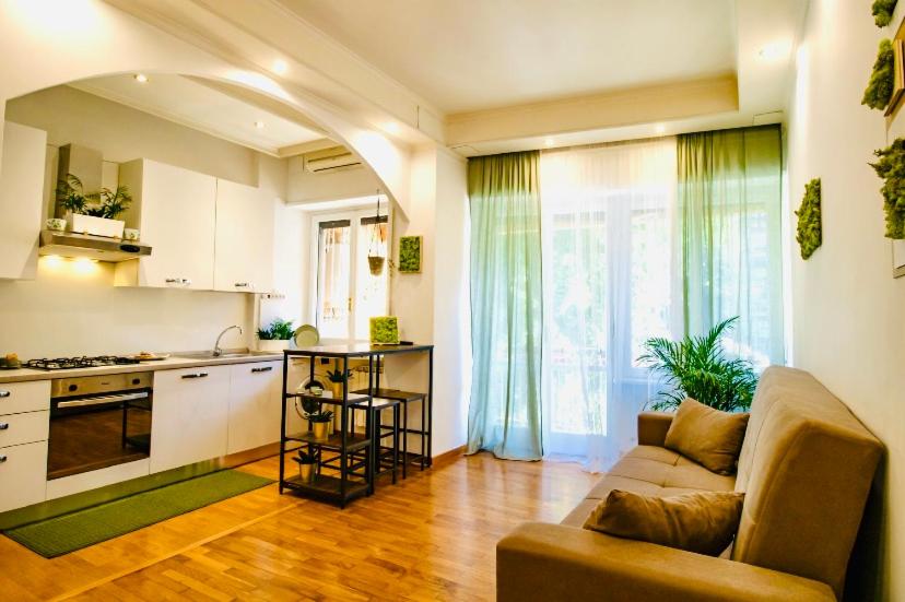 uma sala de estar com um sofá e uma cozinha em PLANT HOUSE Roma Eur em Roma