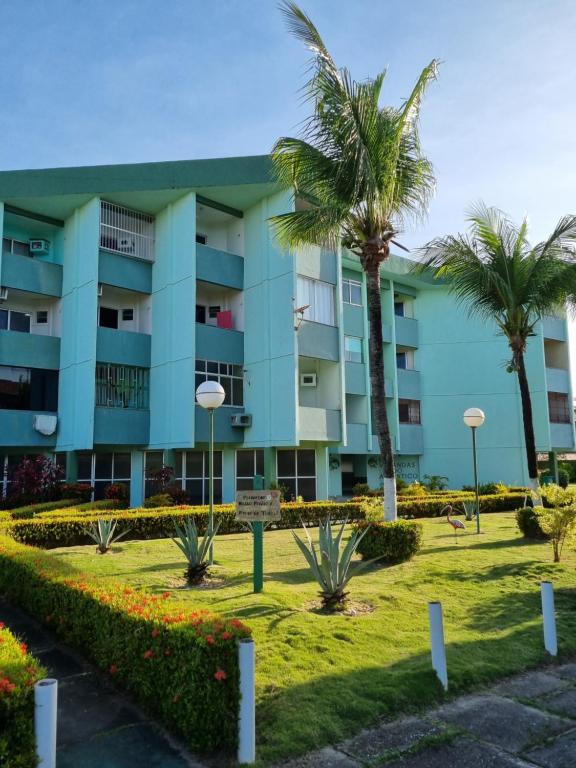 um edifício com palmeiras em frente em Salinópolis - Apartamento Varandas do Atlântico em Salinópolis