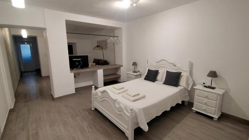 a white bedroom with a white bed and a desk at Castella Aquae II Amplio loft para dos in Mérida