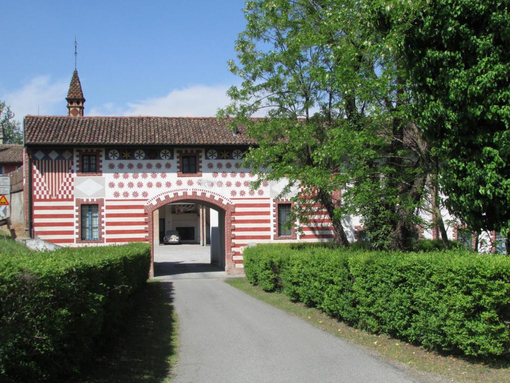 um edifício vermelho e branco com uma arcada em Agriturismo La Costa em Crema