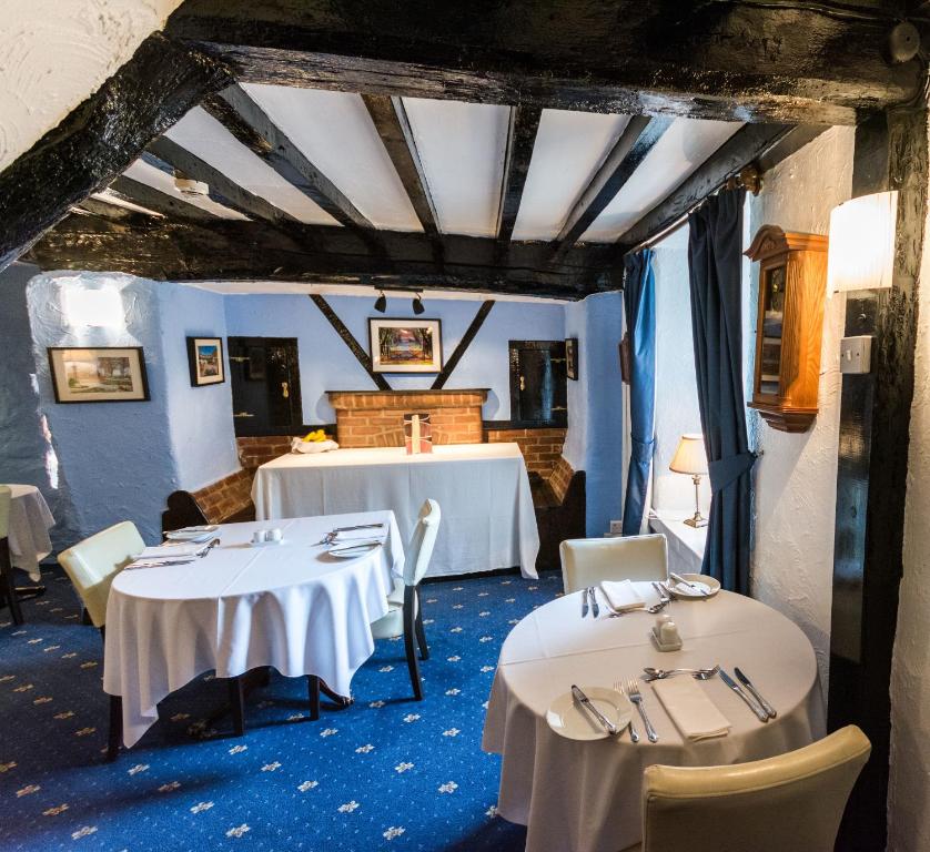 two tables in a room with blue carpet at Gwesty Minffordd Hotel in Tal-y-llyn