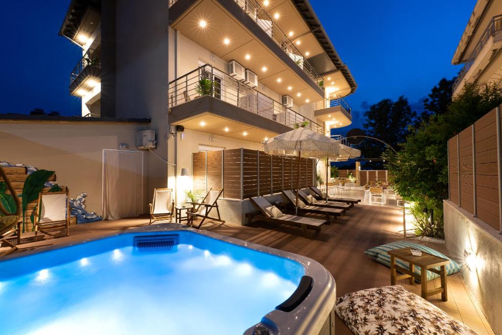 - une piscine dans l'arrière-cour d'une maison la nuit dans l'établissement ELLE Rooms & Suites, à Paralia Katerinis