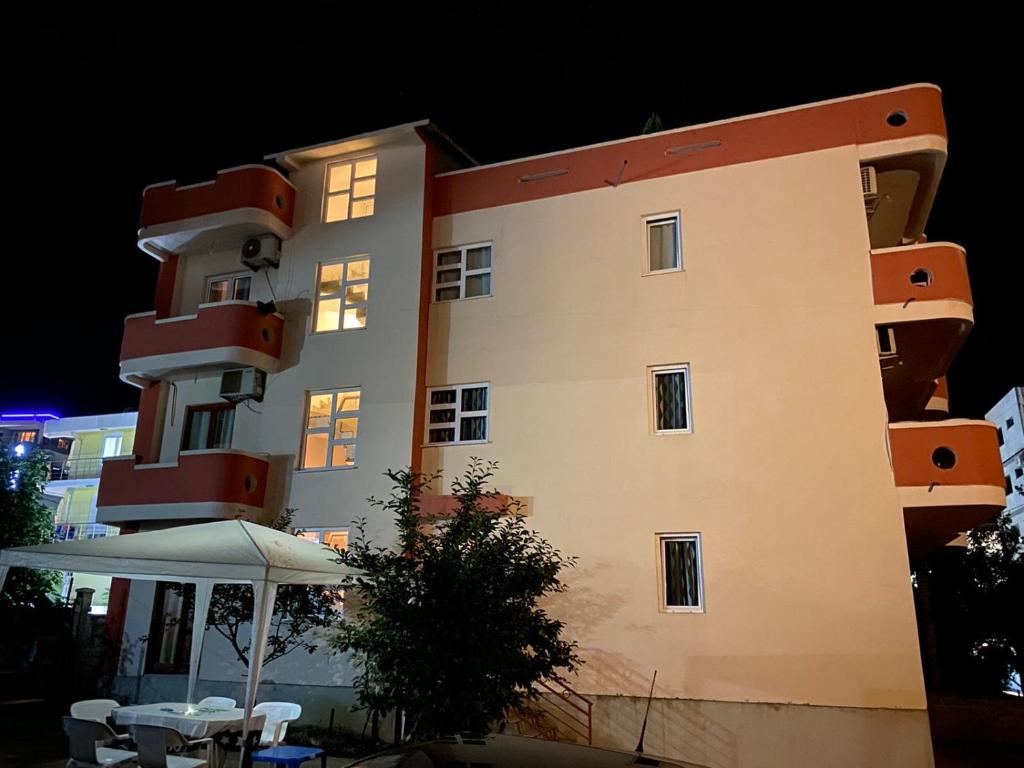 a building at night with a table and an umbrella at Apartments Nurkovic in Dobra Voda