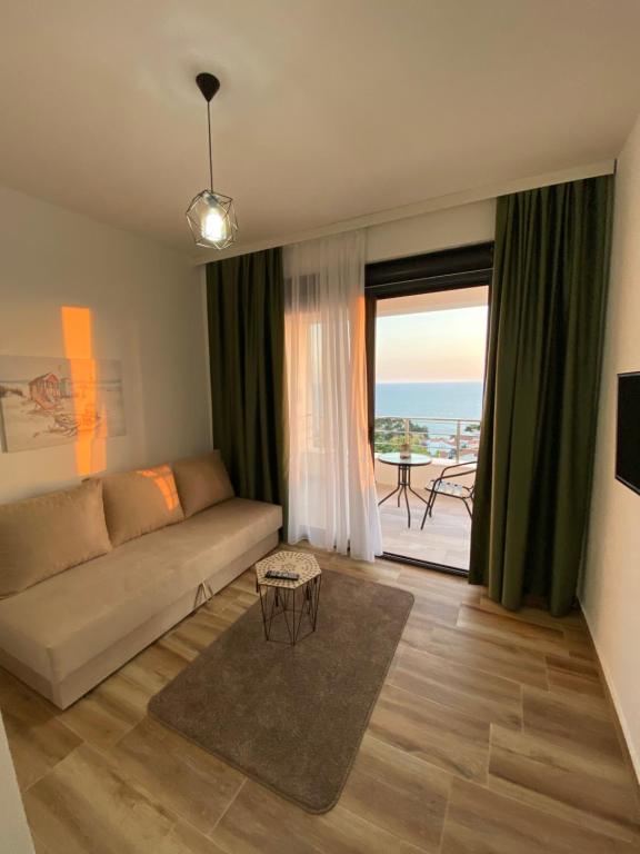 a living room with a couch and a view of the ocean at Xhan Apartments in Ulcinj