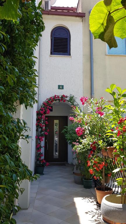 een toegang tot een gebouw met bloemen en planten bij Apartments Danka in Pula