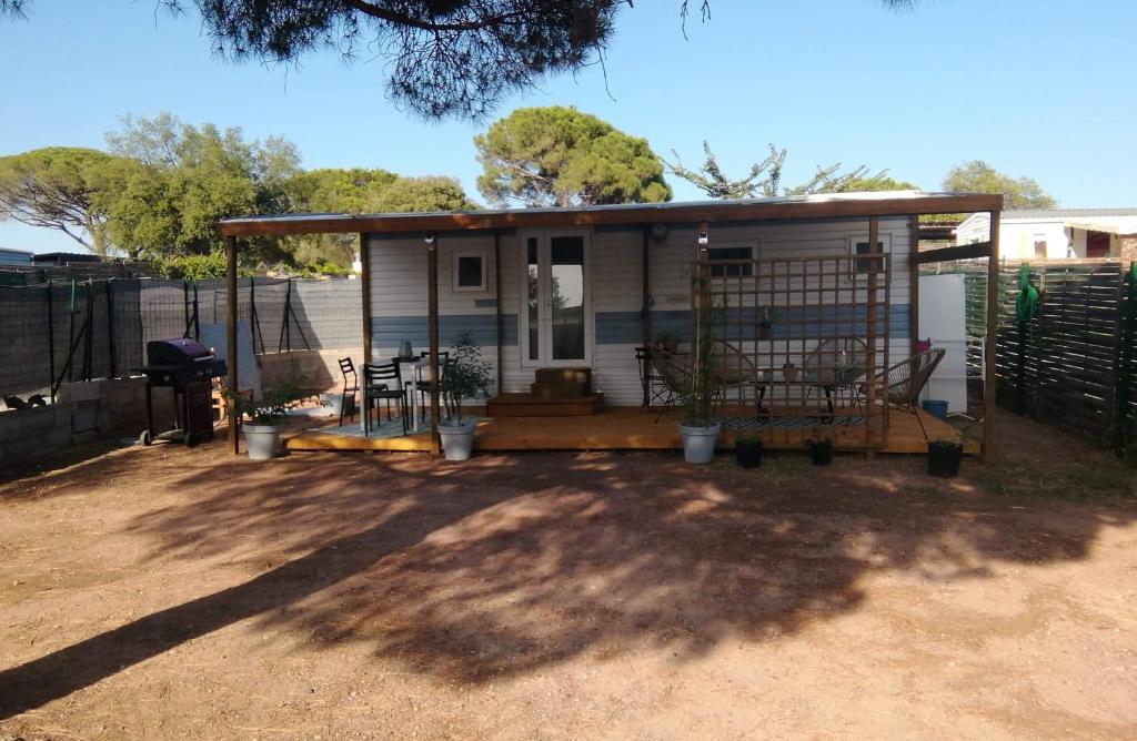 a tiny house with a porch and a fence at Mobilhome à Fréjus à 15 minute de la mer sur terrain indépendant in Fréjus