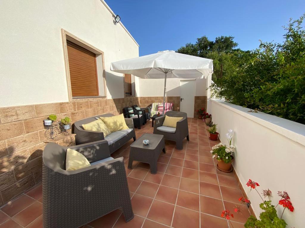 a patio with chairs and an umbrella on a balcony at Alojamientos Tía María in Fernán Pérez