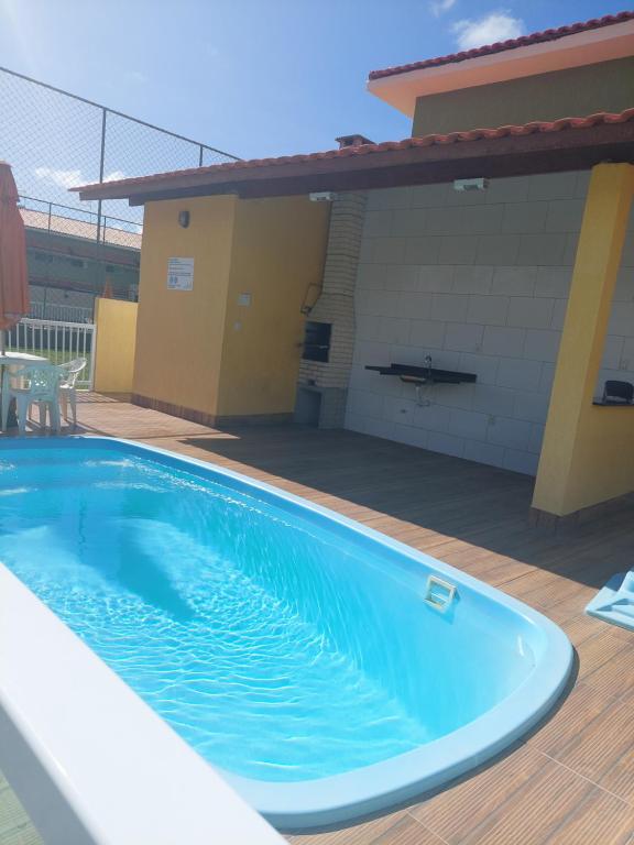 a swimming pool in front of a house at Casa Arembepe em frente as piscinas naturais in Arembepe