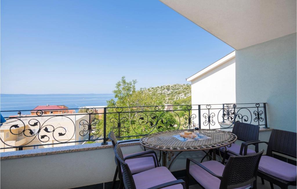 a balcony with tables and chairs and a view of the ocean at 2 Bedroom Beautiful Apartment In Makarska in Makarska