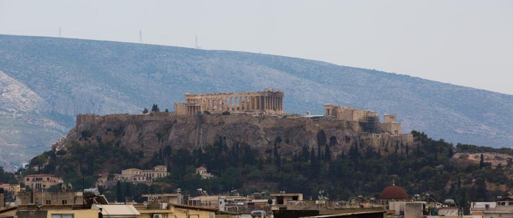 een uitzicht op een berg met een stad erop bij Spacious Modern Apartments With Great Rooftop View in Athene