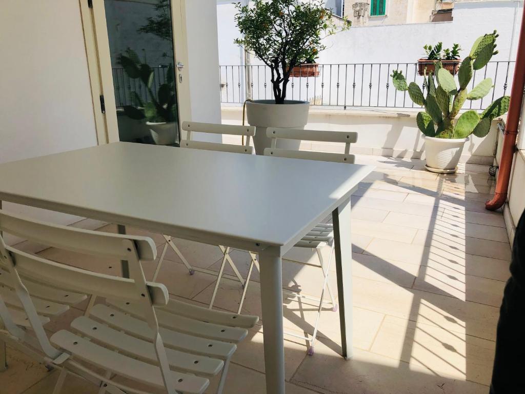 d'une table et de chaises blanches sur un balcon. dans l'établissement Palazzotto "Fasano Antica", à Fasano