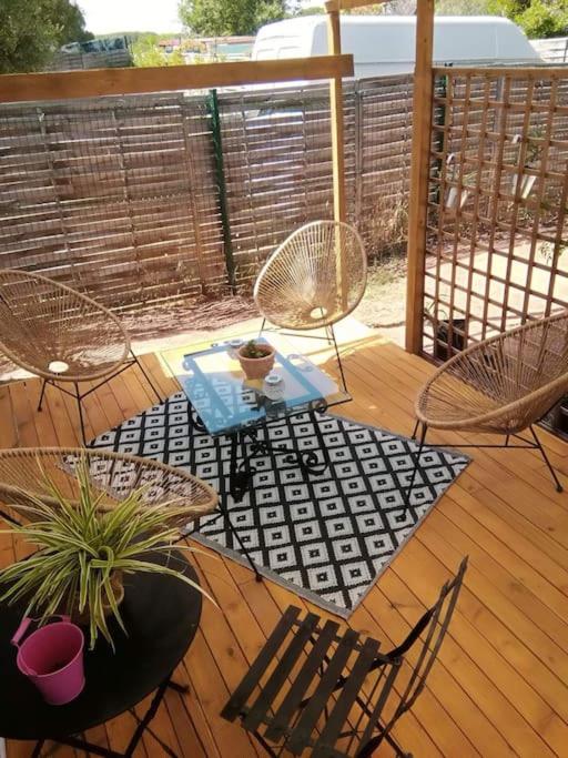 a wooden deck with chairs and a table and a tableablish at Mobilhome à Fréjus à 15 minute de la mer sur terrain indépendant in Fréjus