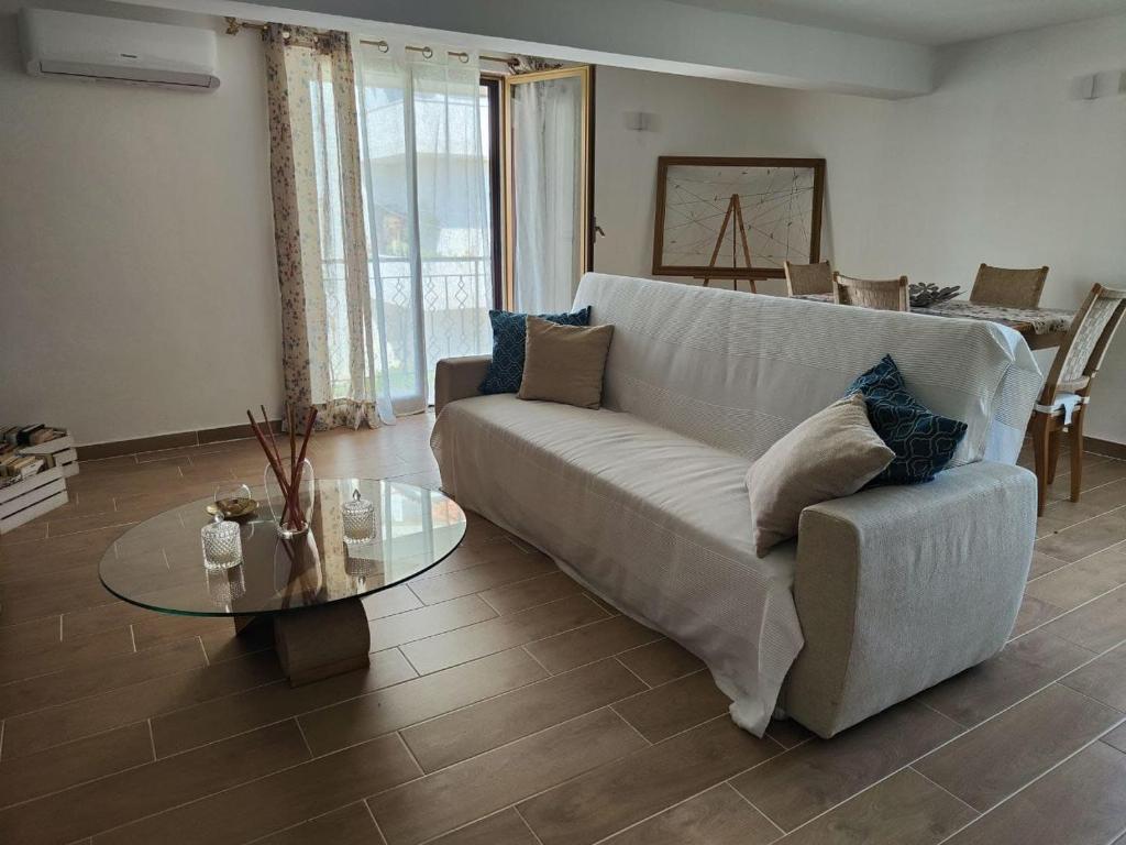 - un salon avec un canapé blanc et une table en verre dans l'établissement Ariosto apartment, à Mondragone