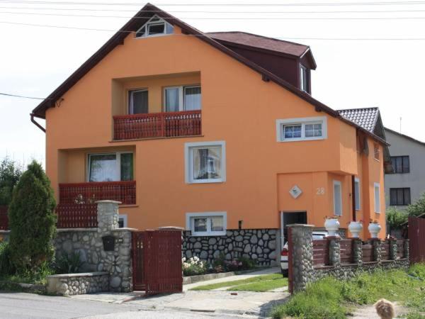 una casa naranja con una valla delante de ella en Privát Kamila, en Nová Lesná