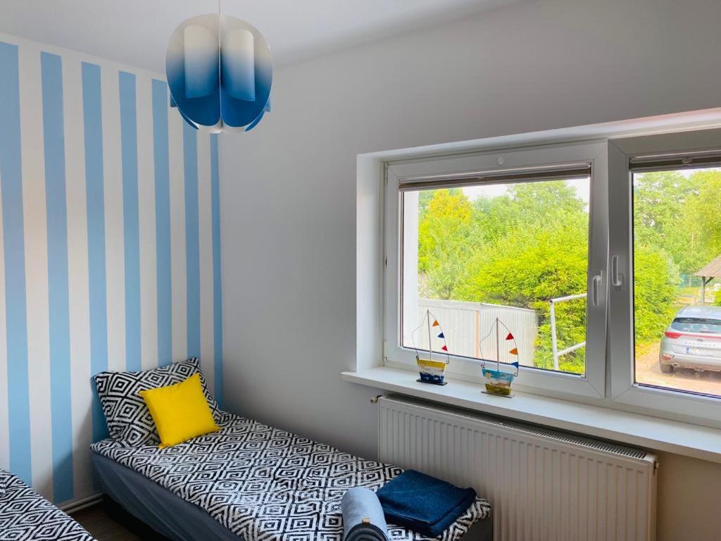 a childs room with a couch and a window at Apartament Morski in Jarosławiec