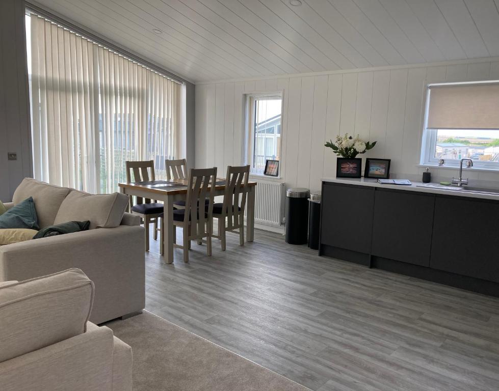 ein Wohnzimmer mit einem Sofa, einem Tisch und Stühlen in der Unterkunft Beach Base Lodge, Padstow Cornwall in Padstow