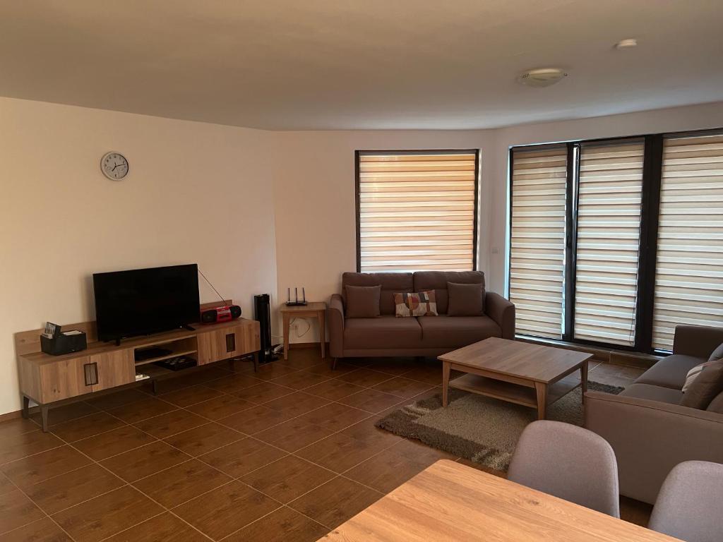 a living room with a couch and a television at Villa Ivana - Bay View Villas in Kosharitsa