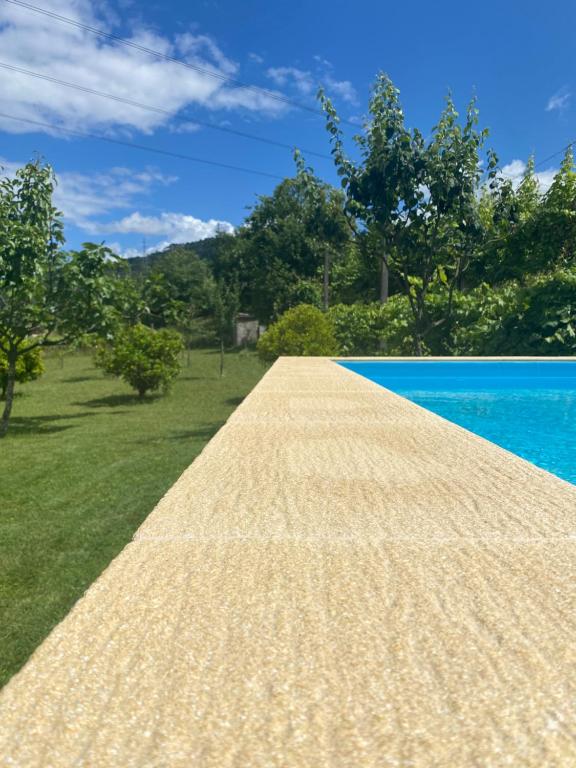 a pathway leading to a swimming pool next to the water at Casa dos Avós in Póvoa de Lanhoso