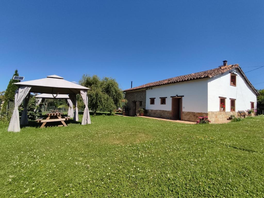 een picknicktafel in een veld naast een wit gebouw bij Casa Pepín - Sagasta Rural Oviedo in Oviedo