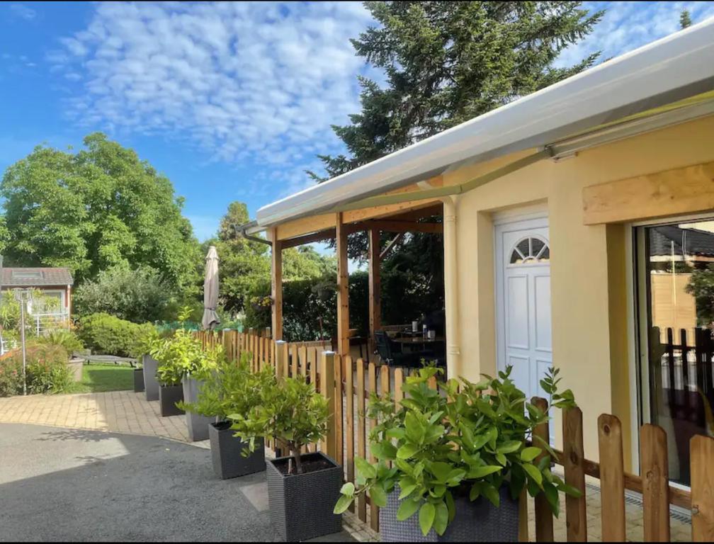 um edifício com vasos de plantas ao lado de uma cerca em Gîte les Noisetiers Maison familiale avec piscine em Joze