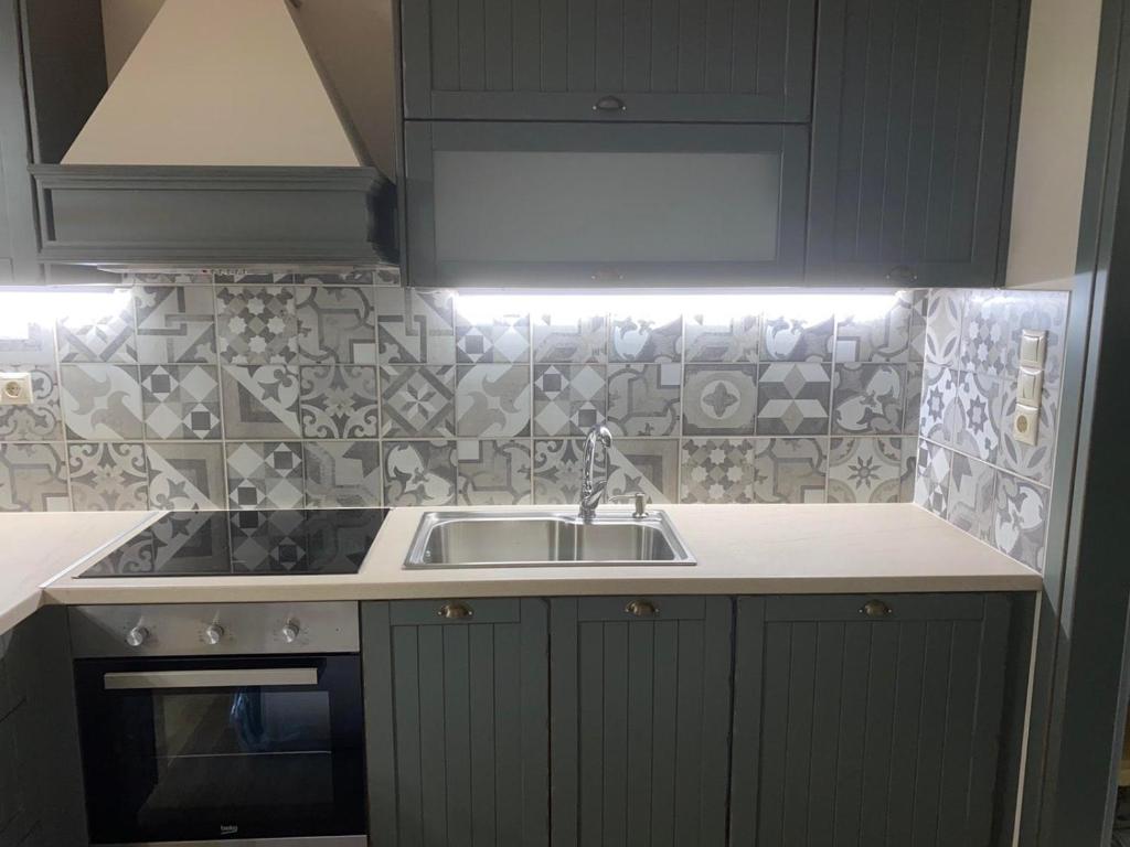 a kitchen with a sink and a counter top at KRATHIS APARTMENTS ΜΕΓΑΛΟ in Paralía Platánou
