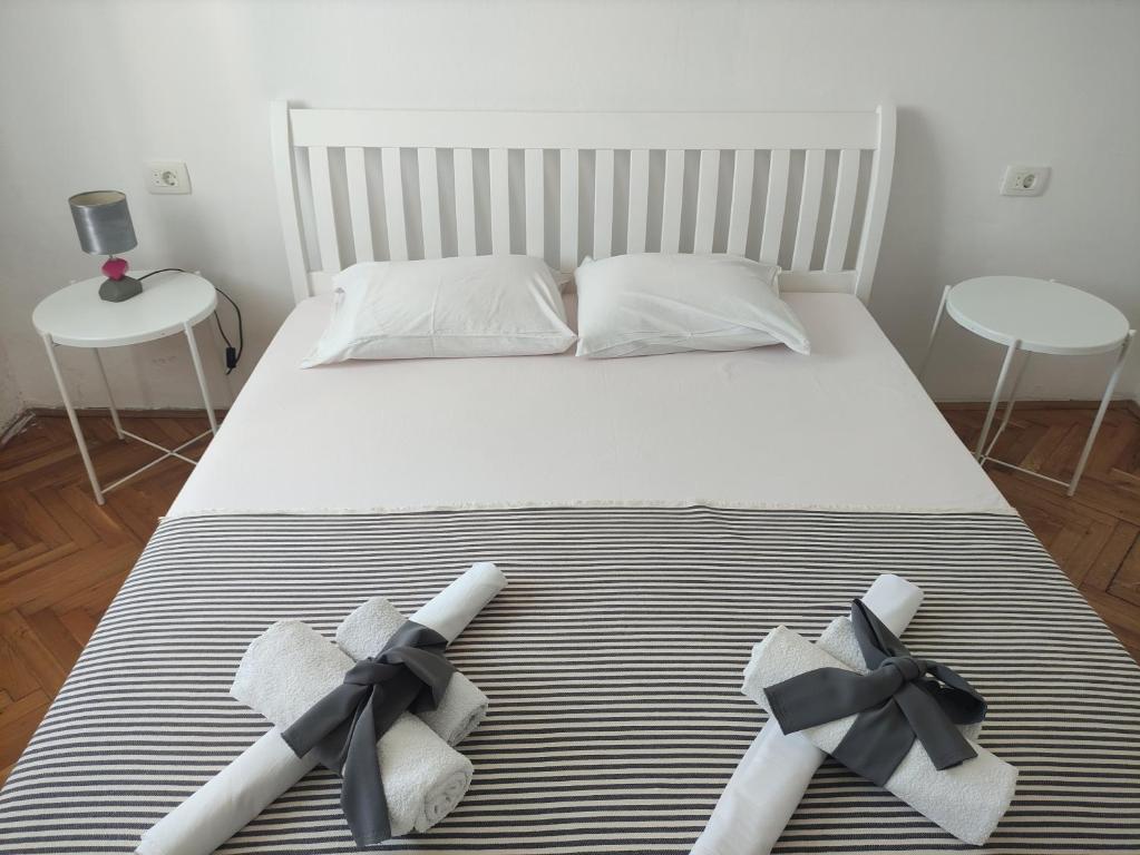 Una cama con arcos negros con dos almohadas en Apartmani More, en Petrovac na Moru