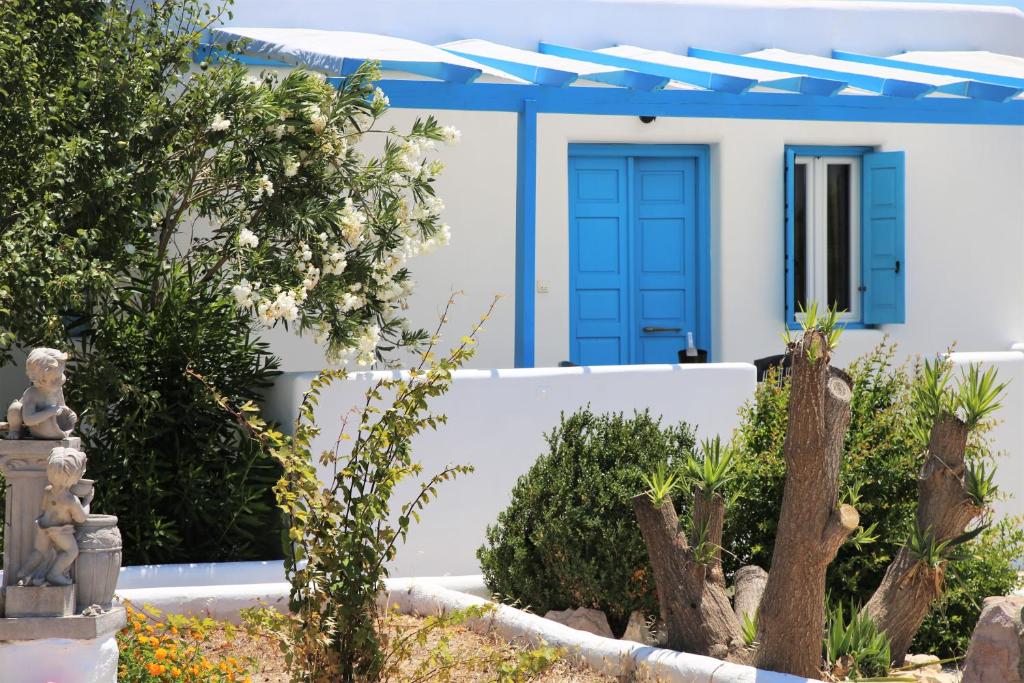 ein Haus mit blauer Tür und einigen Pflanzen in der Unterkunft Alice Maisonette & Studios in Adamas
