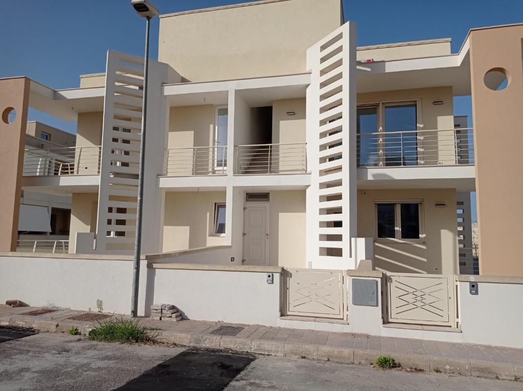 ein Apartmenthaus mit Balkon und Parkplatz in der Unterkunft Gelsimori Apartments in Otranto