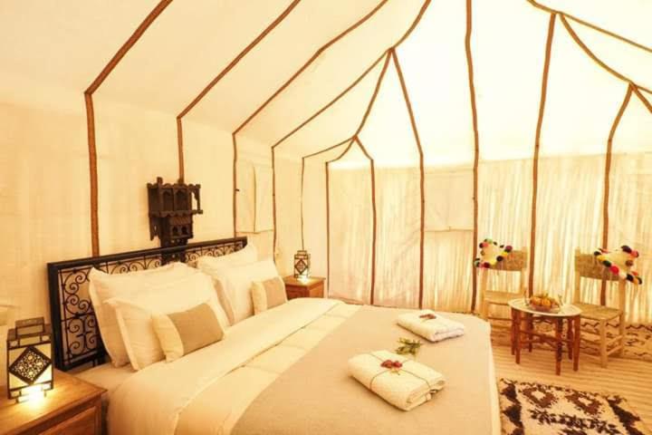 a bedroom with a large bed with two towels on it at Zagora Luxury Camp in Zagora
