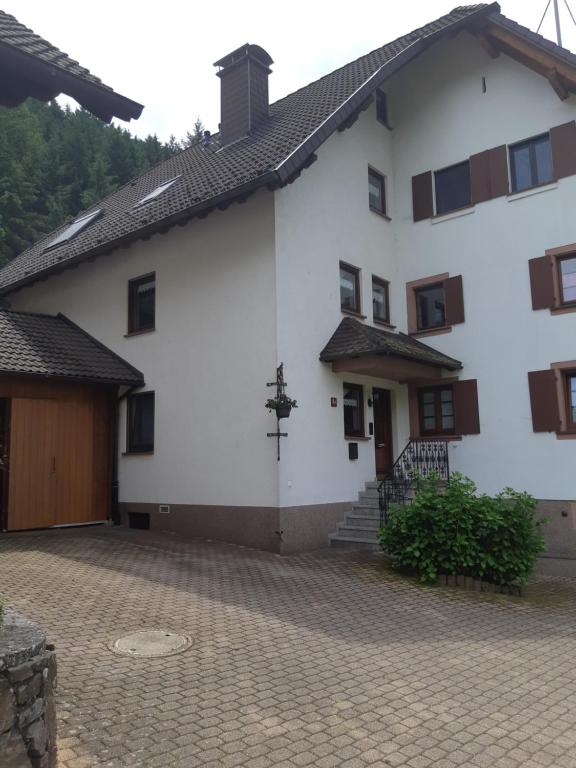 a large white house with a brick driveway at Ferienwohnung Seng in Simonswald