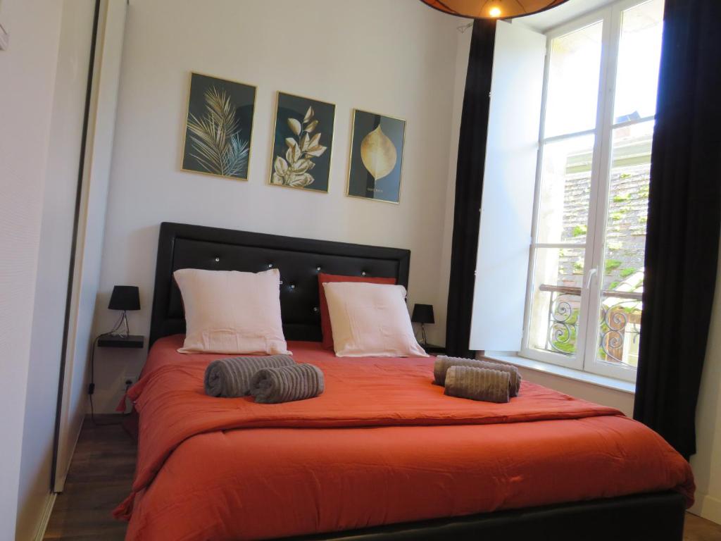 a bedroom with a bed with orange sheets and pillows at La Lauzeta in Sarlat-la-Canéda