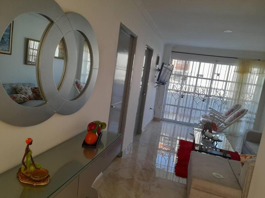 ein Wohnzimmer mit einem Tisch und 2 Spiegeln in der Unterkunft Fantástica cartagena accesible para todos in Cartagena de Indias
