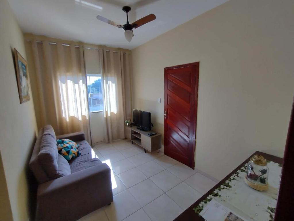 - un salon avec un canapé et une porte rouge dans l'établissement Apartamento da Rosi, à Resende