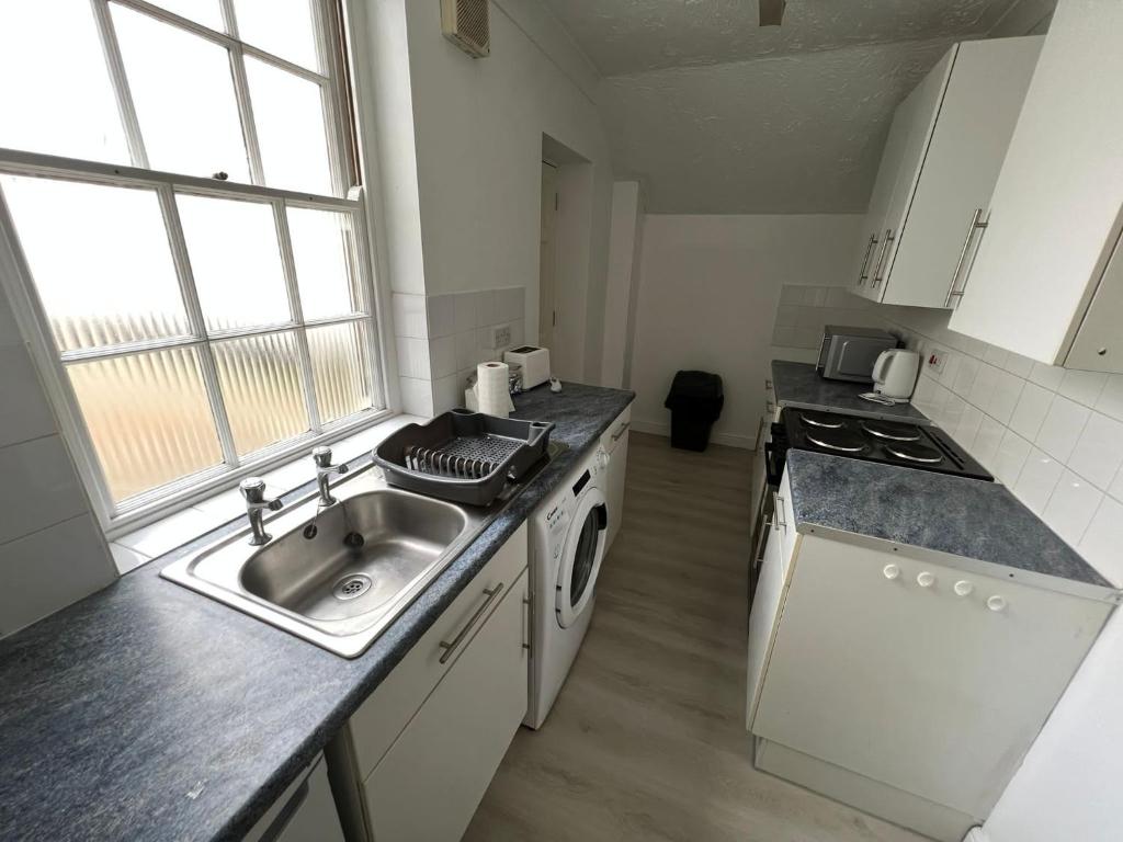 een kleine keuken met een spoelbak en een fornuis bij Entire One Bedroom Flat, 5 in Great Yarmouth
