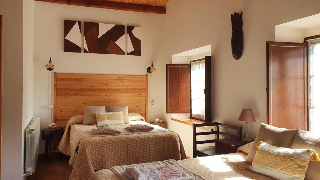 1 dormitorio con 2 camas y 1 silla en Casa Rural Nevada, en Horcadas