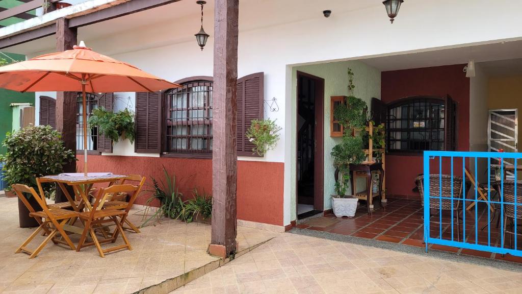 a patio with a table and an umbrella at Lar de Nanci e Beto in Arraial do Cabo