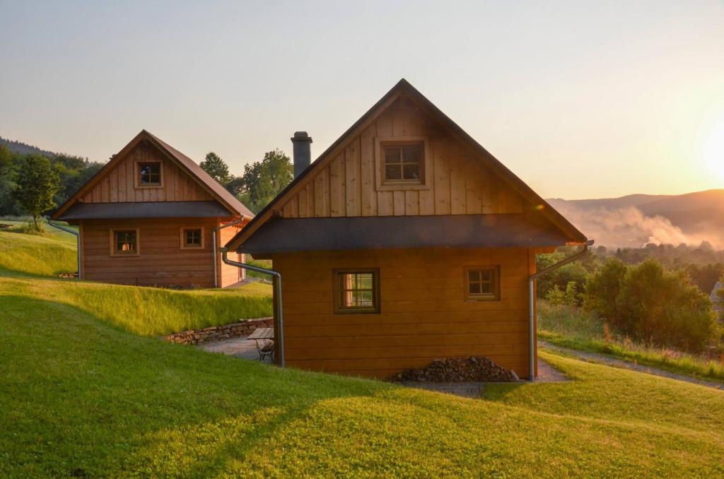 a house sitting on top of a grassy hill at Domki Pod Dębem in Błądzonka