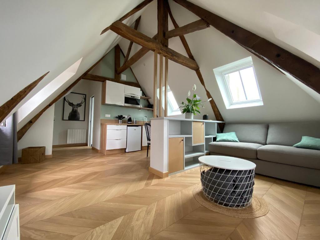 a living room with a couch and a kitchen at Studio centre ville in Dol-de-Bretagne