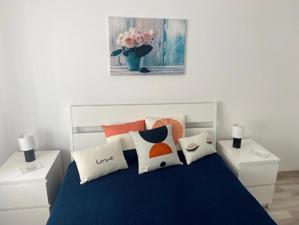 um quarto com uma cama azul com almofadas e um quadro em Mima House Al em Aveiro