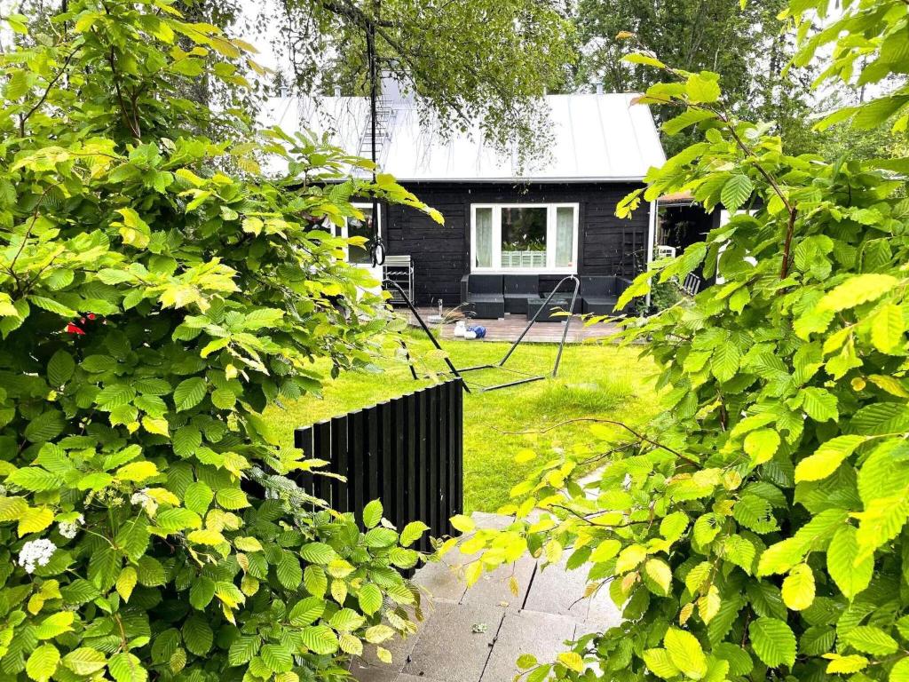 een huis wordt gezien door de bladeren van bomen bij Holiday home SKÖVDE in Skövde