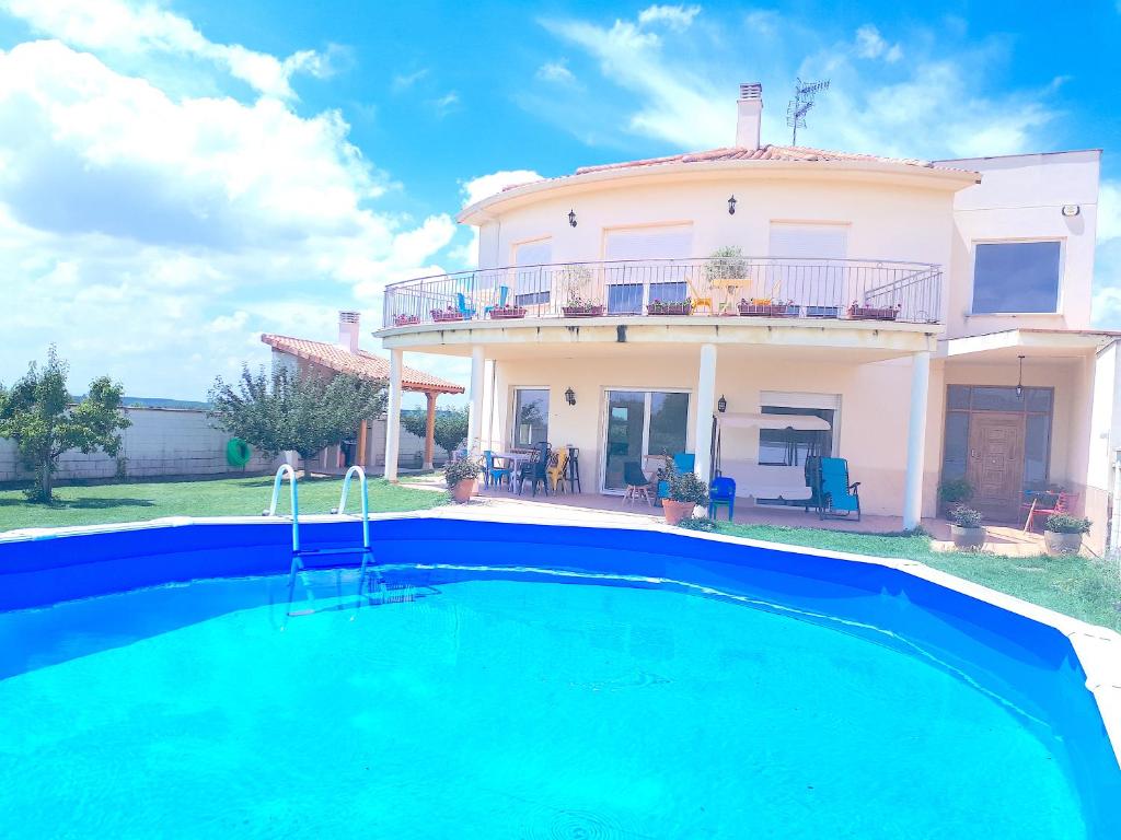 a villa with a swimming pool in front of a house at Casa Miguel & Sally in Villanueva de las Manzanas