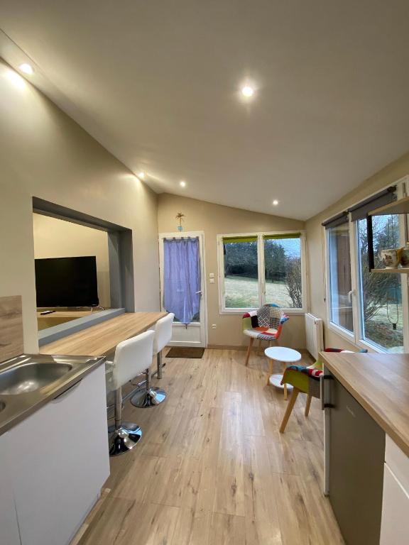 une cuisine et un salon avec une table et des chaises dans l'établissement Gîte cosy en milieu rural, à Lavilleneuve-au-Roi