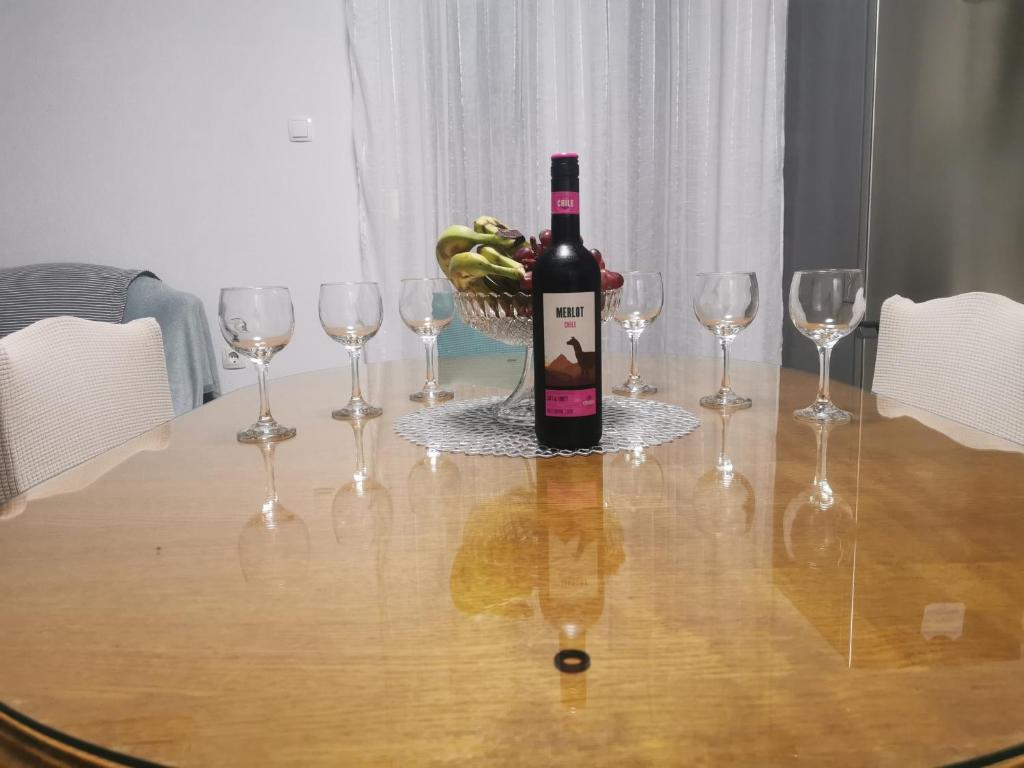 een fles wijn op een tafel met wijnglazen bij Apartman Dany in Kaštela