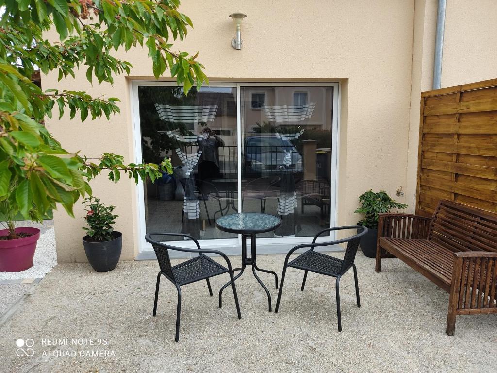 a table and chairs with a table and a bench at Chambre d&#39;hôtes de l&#39;écluse d&#39;Episy avec spa in Épisy