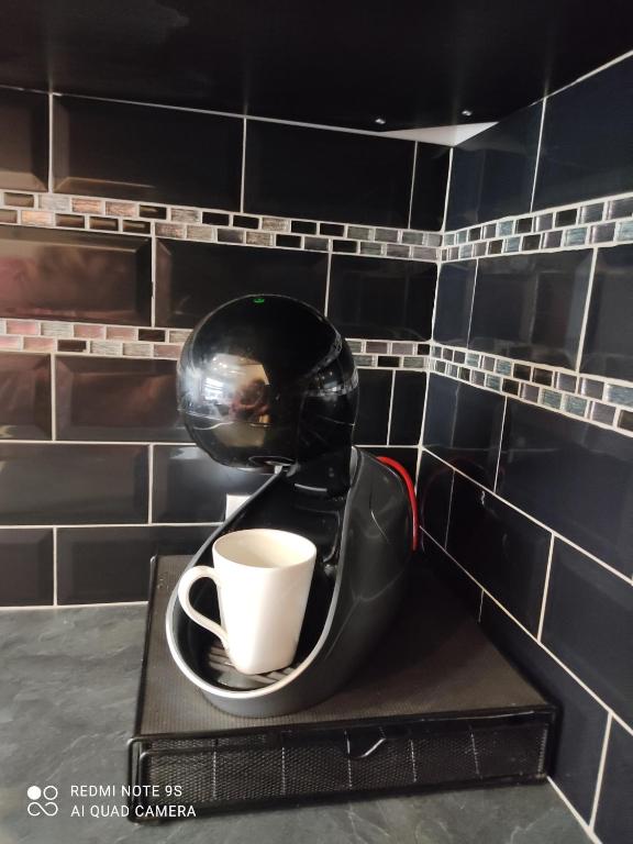 a coffee cup sitting on a holder in a bathroom at Chambre d&#39;hôtes de l&#39;écluse d&#39;Episy avec spa in Épisy