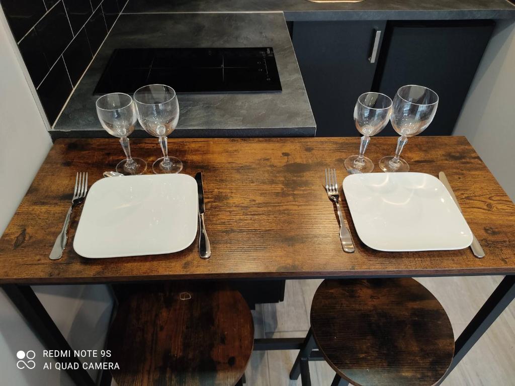 a wooden table with four wine glasses on it at Chambre d&#39;hôtes de l&#39;écluse d&#39;Episy avec spa in Épisy