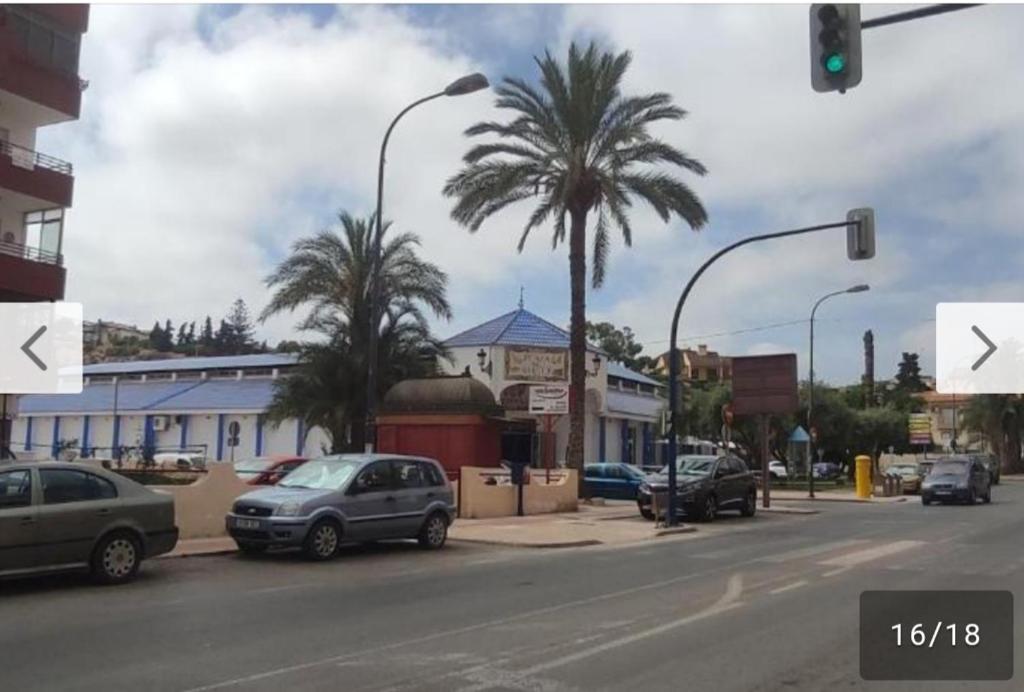 una calle con coches aparcados en una calle con palmeras en Apartamento Puerto de Mazarron en El Puerto de Mazarrón